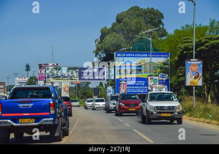 Harare, Zimbabwe. 20 avril 2024 : panneaux publicitaires et trafic sur Borrowdale Road. Crédit : Vuk Valcic/Alamy Banque D'Images