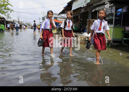 Medan Selayangh, Sumatra du Nord, Indonésie. 20 mai 2024. Trois écoliers ont été forcés de rentrer chez eux avec leurs chaussures, car les zones résidentielles ont été submergées par des crues soudaines, dues au débordement de l'eau de mer. L'Agence de météorologie, climatologie et géophysique a déclaré que les inondations dans la zone côtière de ''‹'''‹ Belawan City (crédit image : © Kartik Byma/ZUMA Press Wire) USAGE ÉDITORIAL SEULEMENT! Non destiné à UN USAGE commercial ! Crédit : ZUMA Press, Inc/Alamy Live News Banque D'Images