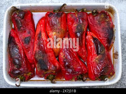 Poivrons rouges farcis avec boulgour et haricots dans une poêle blanche Banque D'Images