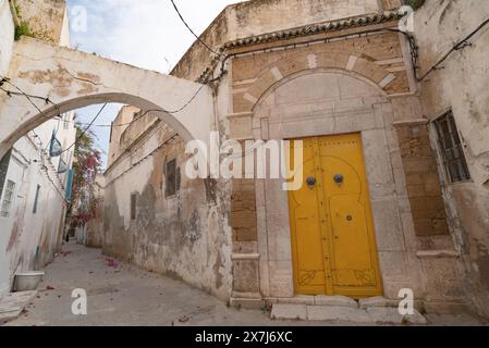 Une porte jaune ornée d'architecture typiquement tunisienne dans les ruelles colorées de la médina de Tunis, capitale de la Tunisie, Afrique du Nord Banque D'Images