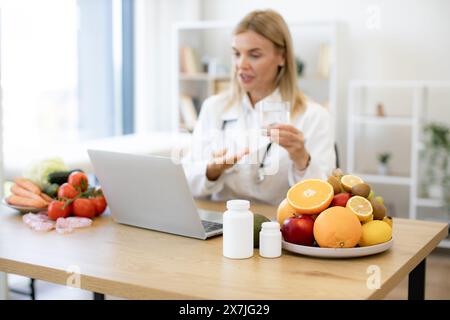 Nutritionniste féminine expérimentée informe le patient des avantages de l'eau Banque D'Images