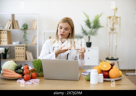 Nutritionniste féminine expérimentée informe le patient des avantages de l'eau Banque D'Images