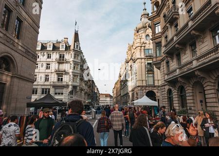 Des foules de gens parcourent les étals d'un marché en plein air animé de Zurich, entouré de bâtiments historiques et ornés Banque D'Images