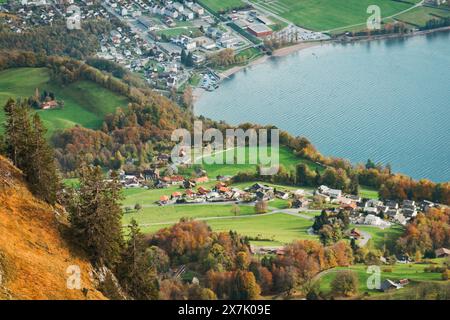 Le pittoresque village de Walenstadt, en Suisse, au bord du lac, entouré de pâturages verdoyants et de feuillages d'automne par une journée calme et claire Banque D'Images