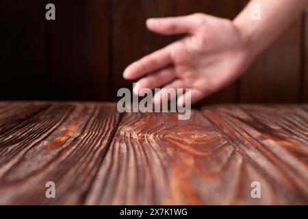 Femme tenant la main au-dessus de la table en bois, mise au point sélective. Espace pour le texte Banque D'Images