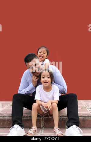 Un père célibataire divorcé passe du temps avec ses deux jeunes filles brune Latina à célébrer la fête des pères dans la pauvreté Banque D'Images