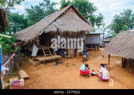 Un groupe familial local heureux Lahu et des bâtiments typiques dans le village de Ban Kiew Karn à Lanjia Lodge, Chiang Khong dans la province de Chiang Rai, au nord de la Thaïlande Banque D'Images