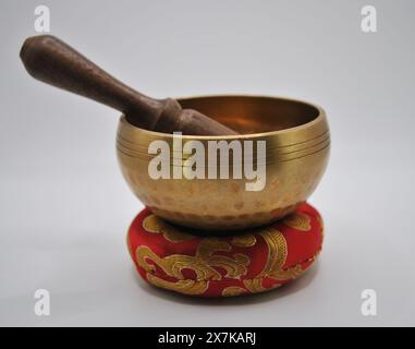 Bol chantant en laiton avec maillet en bois sur l'affichage de coussin rouge, ensemble unique de pièces fabriquées à la main Banque D'Images