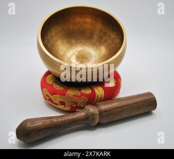 Bol chantant en laiton avec maillet en bois sur l'affichage de coussin rouge, pièce unique fabriquée à la main Banque D'Images