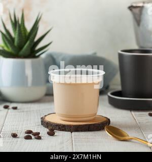panna cotta aromatisée au cappuccino servie dans une tasse en plastique, parfaite pour une expérience de dessert raffinée. Banque D'Images