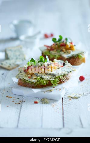 Deux tranches de baguette garnies de fromage bleu, de chutney, de raisins, de pommes et de cresson d'eau Banque D'Images