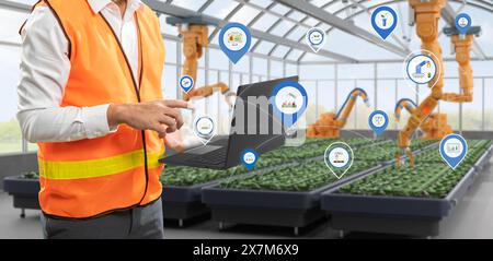 Concept de technologie agricole avec bras robotique de rendu 3d de commande humaine avec tablette numérique en serre Banque D'Images