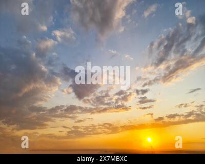 Le ciel était rempli d'un éventail de nuages pendant le coucher du soleil, créant un paysage naturel à couper le souffle avec des teintes d'ambre et de rouge. La rémanence de Banque D'Images