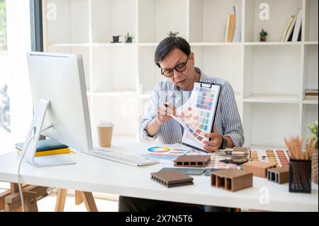 Un designer d'intérieur masculin asiatique expérimenté et professionnel ou architecte a une réunion en ligne avec son équipe et son client, présentant et Banque D'Images