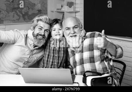 Grand-père, père et son jeux d'ordinateur à l'intérieur. Élève avec Père, grand-père appréciant du temps à la maison. Un homme heureux en famille, amusez-vous ensemble. Trois Banque D'Images