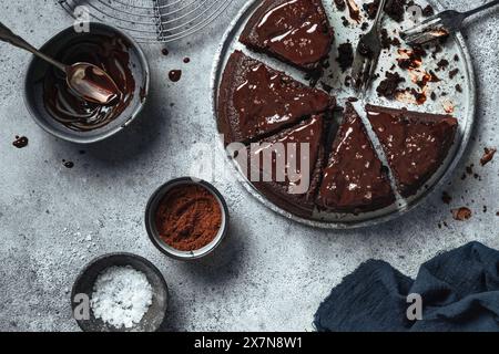 Gâteau au chocolat avec glaçage au chocolat et chocolat fondu sur fond gris. Banque D'Images