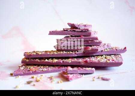 Chocolat rubis fabriqué à partir de variétés de fèves de cacao botaniques sélectionnées. Écorce séchée de fraise et de pistache. Banque D'Images