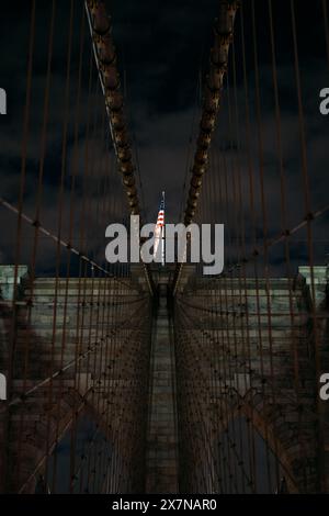 Pont de Brooklyn la nuit avec drapeau américain à New York Banque D'Images