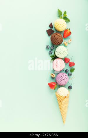 Boules de crème glacée volantes et ingrédients sur fond bleu clair pastel. Concept minimal d'été Banque D'Images