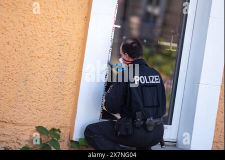 Hoppegarten, Allemagne. 21 mai 2024. Un policier obtient des preuves à la porte d'un restaurant à Hoppegarten. Une fenêtre du restaurant avait été brisée, la façade enduite et de l'acide butyrique distribué. Le restaurant avait récemment été le lieu d'une foire du livre de droite organisée par un politicien de l'AFD. Les pompiers ont été déployés avec une vingtaine de véhicules à cause de l'acide butyrique. Crédit : Christophe Gateau/dpa/Alamy Live News Banque D'Images