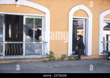 Hoppegarten, Allemagne. 21 mai 2024. Un policier obtient des preuves à la porte d'un restaurant à Hoppegarten. Une fenêtre du restaurant avait été brisée, la façade enduite et de l'acide butyrique distribué. Le restaurant avait récemment été le lieu d'une foire du livre de droite organisée par un politicien de l'AFD. Les pompiers ont été déployés avec une vingtaine de véhicules à cause de l'acide butyrique. Crédit : Christophe Gateau/dpa/Alamy Live News Banque D'Images