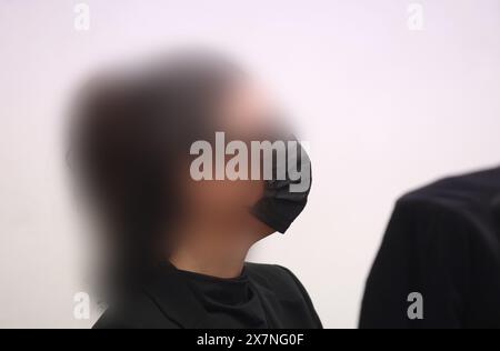 Memmingen, Allemagne. 21 mai 2024. Une femme de 34 ans est assise sur le banc des accusés du tribunal régional. Une femme de 34 ans doit être jugée pour meurtre au tribunal de district de Memmingen à partir de mardi (8 h 9,00) pour avoir tué son mari dans un incendie par cupidité. Selon l’acte d’accusation, l’homme de 38 ans est mort en mai de l’année dernière des suites d’une inhalation de fumée dans l’appartement que le couple partageait à Memmingen. Crédit : Karl-Josef Hildenbrand/dpa - ATTENTION : personne(s) a/ont été pixelisée(s) pour des raisons légales/dpa/Alamy Live News Banque D'Images