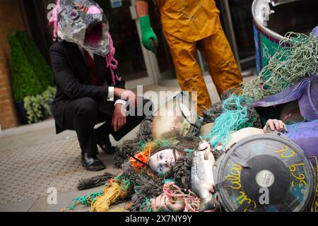 Les militants de Ocean Rebellion prennent part à une manifestation devant l'hôtel Hilton, dans le centre de Londres, où se déroule le Blue Food innovation Summit. Date de la photo : mardi 21 mai 2024. Banque D'Images