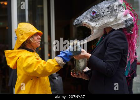 Les militants de Ocean Rebellion prennent part à une manifestation devant l'hôtel Hilton, dans le centre de Londres, où se déroule le Blue Food innovation Summit. Date de la photo : mardi 21 mai 2024. Banque D'Images