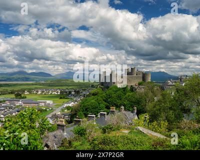 Construit dans les années 1280, le château de Harlech se dresse sur une haute falaise et photographié lors d'une magnifique journée d'été claire avec des nuages spectaculaires et un ciel bleu profond. Banque D'Images