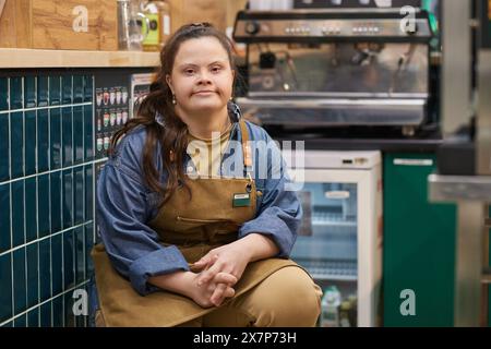 Portrait d'une femme adulte indépendante avec le syndrome de Down travaillant dans un café et regardant la caméra avec l'espace de copie de confiance Banque D'Images