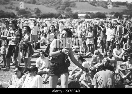 FEMME, DANSANT AVEC CIGARETTE ET BOUTEILLE DE VIN, SCÈNE NME, GLASTONBURY 95 : une jeune femme dansant dans la vaste foule tenant une cigarette et une bouteille de vin au deuxième stade NME au Glastonbury Festival, Pilton Farm, Somerset, Angleterre, 24 juin 1995. En 1995, le festival a célébré son 25e anniversaire. Beaucoup de gens ont lutté avec un coup de chaleur lors du week-end particulièrement chaud. Photo : ROB WATKINS Banque D'Images