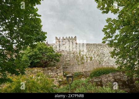 Mur extérieur du château Castro Laboreiro au Portugal par une journée nuageuse avec des arbres et une couleur verdâtre de la végétation. Vue de dessous Banque D'Images