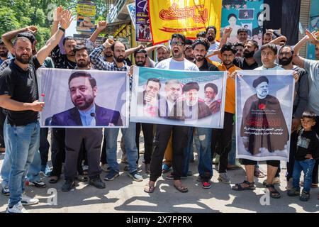 Srinagar, Cachemire. 21 mai 2024. Les musulmans tiennent des banderoles du président iranien Ebrahim Raisi et d'autres responsables alors qu'ils crient des slogans pro-iraniens et islamiques lors d'un rassemblement à Srinagar. Des centaines de manifestants se sont rassemblés pour la marche en deuil de la mort tragique du président iranien Ebrahim Raisi, ainsi que du ministre des Affaires étrangères Hossein Amirabdollahian et d'autres responsables. Les responsables ont été retrouvés morts le 20 mai après que les équipes de secours ont découvert que leur hélicoptère s'était écrasé dans un brouillard dense dans une région montagneuse du nord-ouest du pays, ont déclaré des responsables et des médias d'État. Crédit : SOPA images limite Banque D'Images