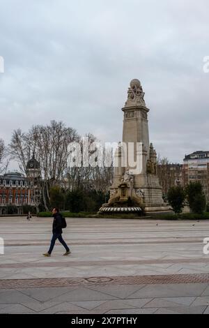 Madrid, Espagne. 13 février 2024 - Un homme marchant sur la Plaza de Espana avec le monument Cervantes en arrière-plan. Banque D'Images