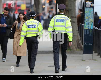 Un homme et une femme policiers patrouillent Whitehall, Londres, Royaume-Uni Banque D'Images