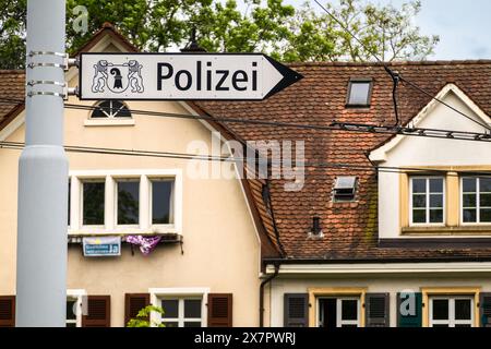 Bâle, Suisse - 18 mai 2024 : L'image montre un panneau de rue allemand Polizei pointant vers un poste de police, avec un bâtiment derrière. Banque D'Images