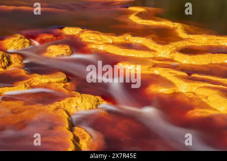 Un gros plan captivant de la rivière Riotinto, mettant en valeur les oranges et les rouges spectaculaires et vibrants qui marquent l'eau unique de la rivière en raison de son caractère exceptionnel Banque D'Images