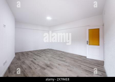 Capturez l'essence de la vie moderne avec cet intérieur d'appartement vide lumineux et expansif. Les murs blancs et le plancher en bois laminé Highligh Banque D'Images