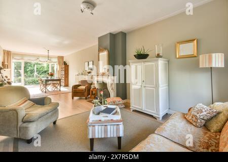 Ce salon bien aménagé du Meester Rendorplaan 8 dispose d'un canapé confortable, d'une cheminée classique et d'un mobilier de bon goût, donnant sur une garde sereine Banque D'Images