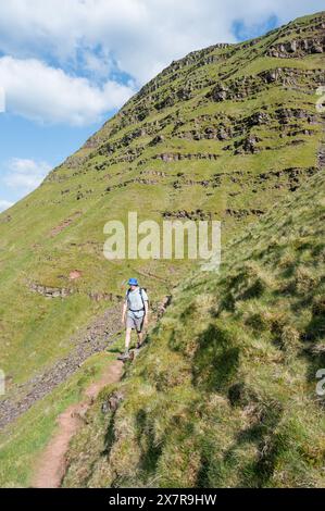 Homme marchant sur le sentier de Cribyn face, face nord-est de Pen y Fan Banque D'Images