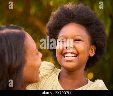 Aimer mère et fille rire et s'embrasser à l'extérieur dans la campagne ou le jardin Banque D'Images