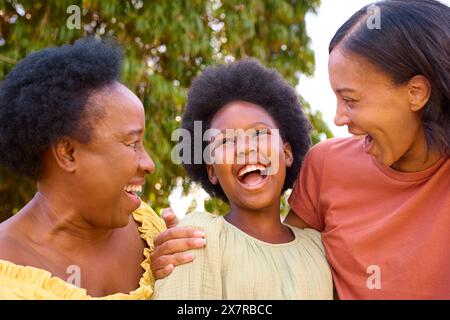 Famille féminine de trois générations rire et s'embrasser à l'extérieur à la campagne Banque D'Images