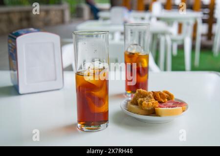 Apéritif espagnol : deux verres de vermouth et tapa dans une terrasse. L'Espagne. Banque D'Images