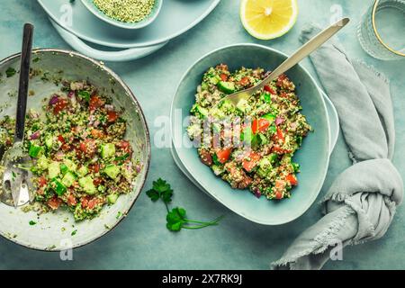 Salade de taboulé. Salade Tabouli maison fraîche avec persil frais, oignons, tomates et graines de chanvre. Banque D'Images