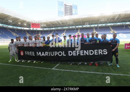 DNIPRO, UKRAINE - 19 MAI 2024 - les joueurs du FC Shakhtar Donetsk (kit blanc) et du SC Dnipro-1 (kit bleu) tiennent la bannière avant le match de la première Ligue ukrainienne 2023/2024 Round 29 à la Dnipro Arena, Dnipro, dans le centre de l'Ukraine. Banque D'Images