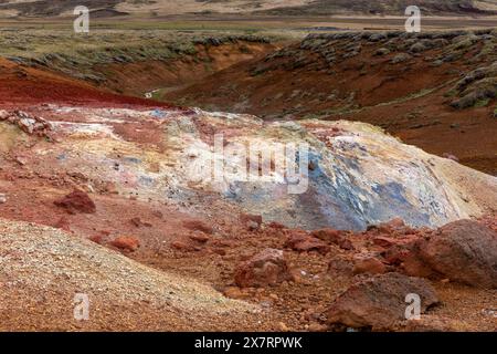 Sols et pierres soufrés rouges, oranges et bleus dans la zone géothermique de Seltun à Krysuvik, Islande. Banque D'Images