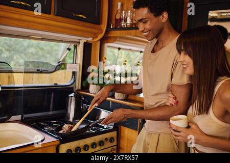 Un couple interracial cuisinant dans leur camping-car, préparant un repas ensemble dans les confins confortables de leur cuisine mobile. Banque D'Images