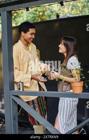 Un homme et une femme se tiennent ensemble sur un balcon, profitant de la vue sur l'environnement naturel qui les entoure. Banque D'Images