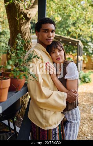 Un homme et une femme de races différentes se tiennent unis l'un à côté de l'autre, expérimentant l'amour et la compagnie dans un cadre naturel magnifique. Banque D'Images
