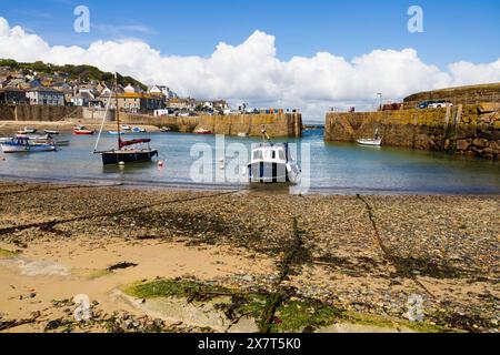 Bateaux dans le port à mi-marée, plage et chaînes d'amarrage. Le pittoresque village de pêcheurs de Mousehole, Cornouailles, West Country, Angleterre Banque D'Images